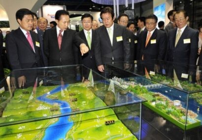  Ông Lee Myung-bak (thứ hai từ trái qua) quan sát mô hình dự án Hồi phục Bốn dòng sông tại trung tâm triển lãm ở Seoul (Ảnh: Hani)